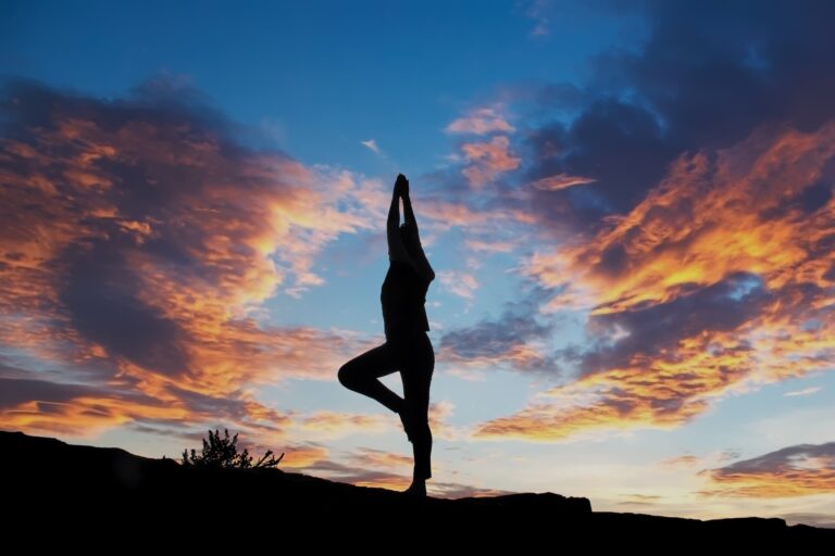 Woman doing yoga at sunrise after taking biological age test.