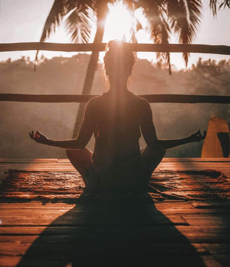 A woman meditating outside to prevent widowmaker heart attack.