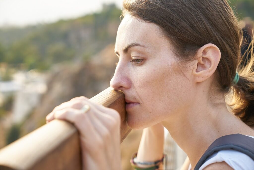 Woman with the symptoms of chronic inflammation standing outside.